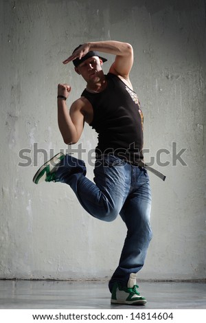 cool looking  dancer posing on old wall