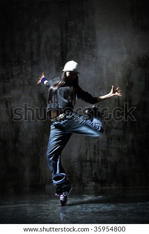 modern dancer poses in front of the old dirty wall
