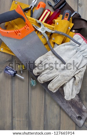 Home renovation in progress. Tool belt with various tools against wooden surface, add your text.