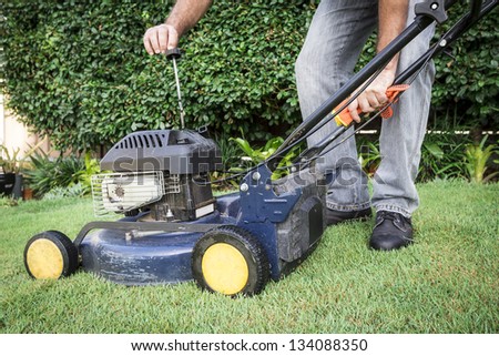 A low angle view of a man preparing for lawn mowing
