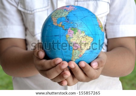 A conceptual image of a boy holding the earth globe with his two hand. A symbol of hope, future generation and  saving the planet for future generation.