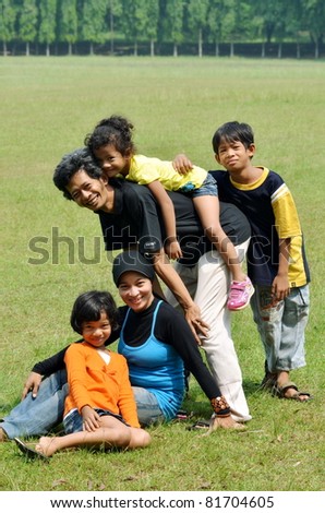 An asian happy family posing together in outdoor scene