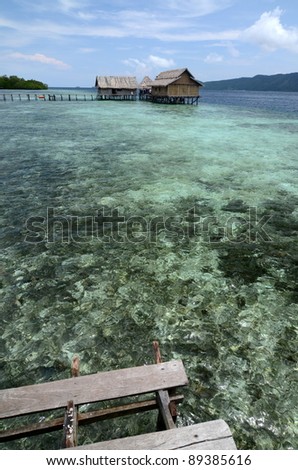 A boat dock on tropical beach with clean water and beautiful scenery. This picture taken in one of the most beautiful travel and diving destination on earth. Raja Ampat Island, Papua, Indonesia.