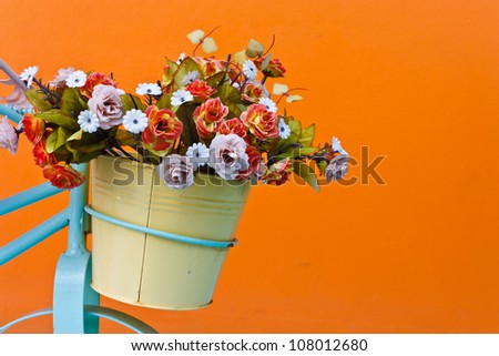 decorative the bicycle with artificial flowers on color wall background