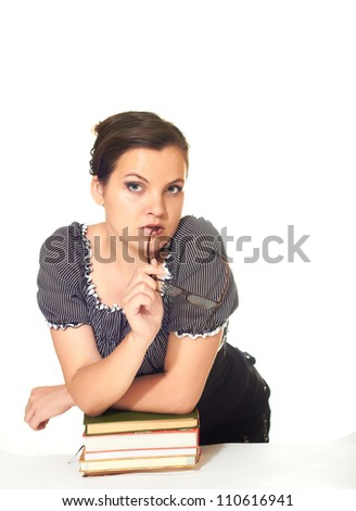 attractive girl in a blouse holds in his right hand points and is leaning on a pile of books isolated on white background