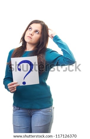 Attractive young woman in a blue shirt holding a poster with a big question mark and looking thoughtfully into the upper-right corner. Isolated on white background