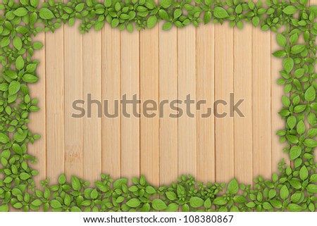 wooden plank background with green plant frame