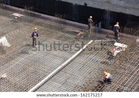 workers make metal reinforcement for the concrete foundation