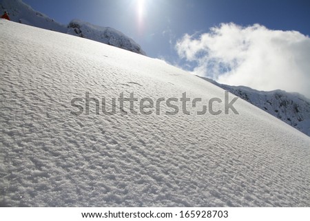 off-piste ski slope in powder snow and scenic alpine background