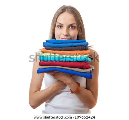 young woman holding a pile of clothes, isolated on white background