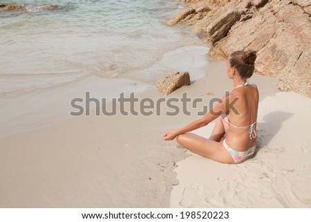 woman practicing morning meditation in nature at the beach
