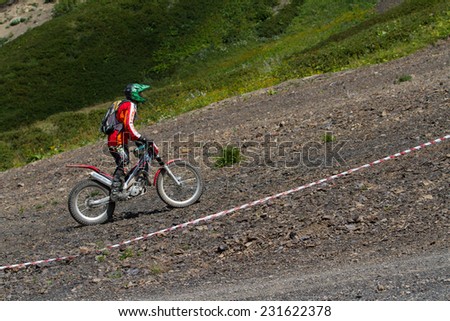 SOCHI, RUSSIA -AUGUST 16, 2014: Off-road motorcycle rider trains in summer mountains