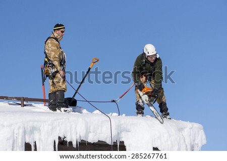 SOCHI, RUSSIA - JANUARY 22, 2015: Industrial climbers take off the snow and icicles from the roof