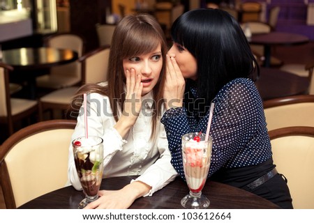 one woman whisper something to friend