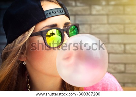 Beautiful yyoung woman blowing a bubble gum balloon