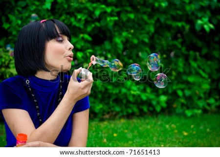 young female makes soap bubbles