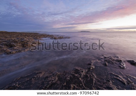 Irish coast line at sunrise. Warm and colorful landscape photograph of a beautiful shore in Ireland, Europe.