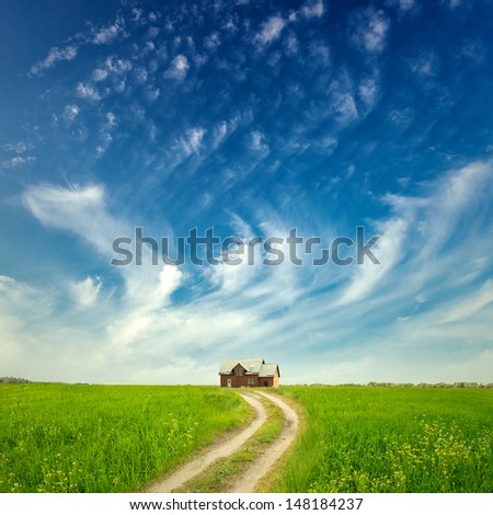 Green Grass Field Landscape with road and fantastic clouds in the background