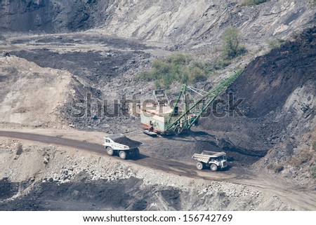 Dredger loading truck with stone from large quarry