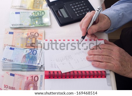 Old man calculating home budget by hand