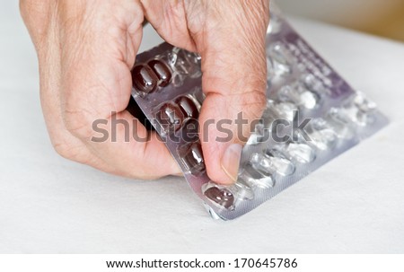 Close up of man\'s hand taking out pills from blister