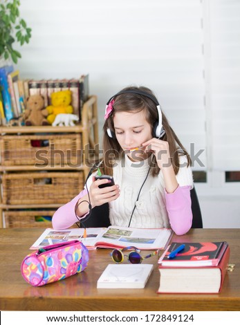 School girl listens music on cell phone instead of learning