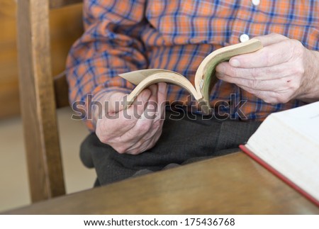 Close up of old man hands with open book