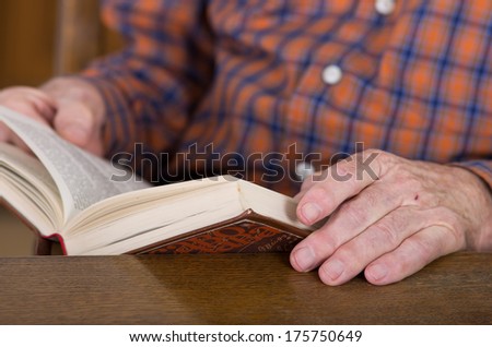 Close up of old man\'s hands who\'s reading book