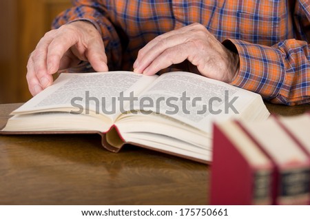 Close up of old man\'s hands who\'s reading book