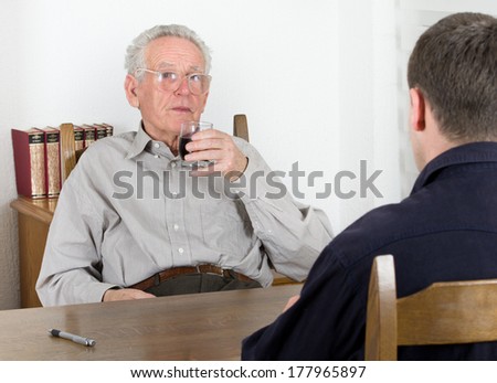 Old man drinking wine and listening young man stories