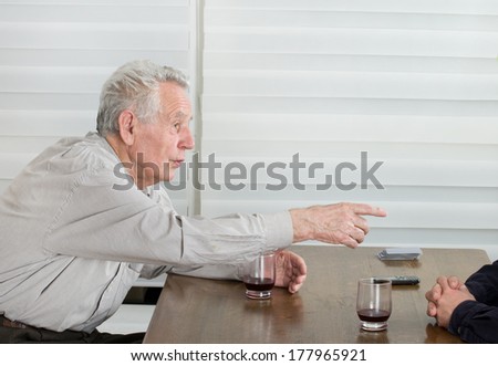 Old man drinking and telling stories to another man.