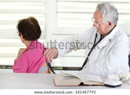 Senior doctor listening patient\'s heartbeat with stethoscope
