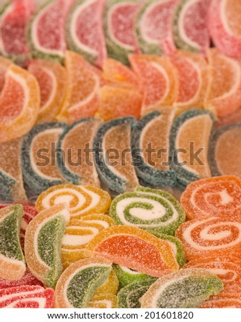 Colorful jelly fruit candies and candy rolls as background