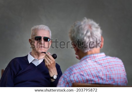 Two old man with sunglasses discussing about secret subjects