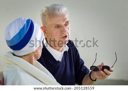 Old man explaining something to older woman