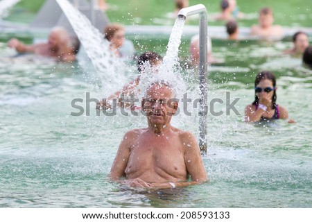 Senior man enjoying waterfall in hot water pool