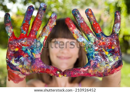 Young student girl showing colorful painted hands