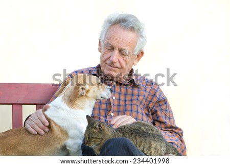 Senior man with dog and cat on his lap on bench