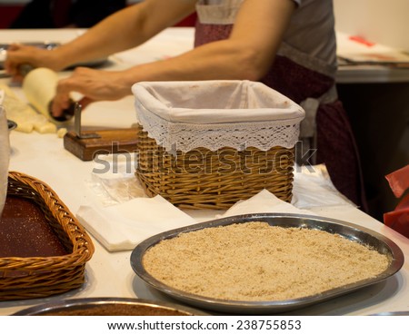 Woman with apron baking chimney cake in kitchen
