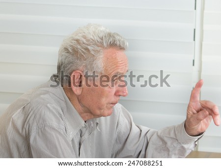 Wise old man talking with forefinger up in the air
