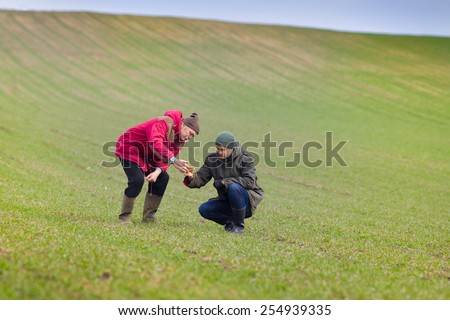 Two farmers monitoring seedlings in the field in winter time