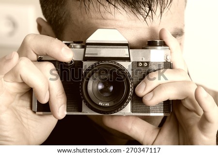 Young man holding old fashioned slr camera