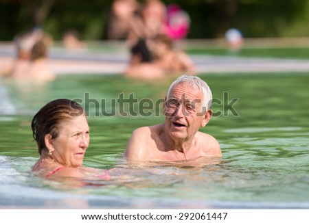 Senior couple enjoying sun and holiday in the pool with hot water