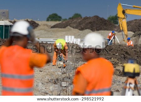 Construction workers working on different jobs at building site