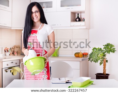 Young woman using mixer for baking cookies in the kitchen