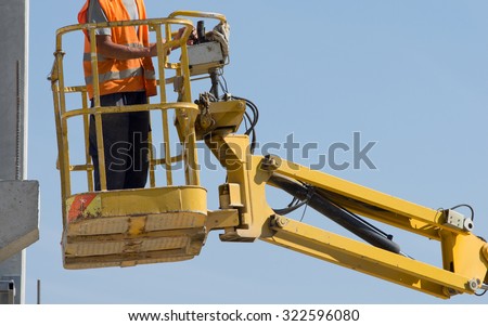 Construction worker operating with lifting security cage for works on height