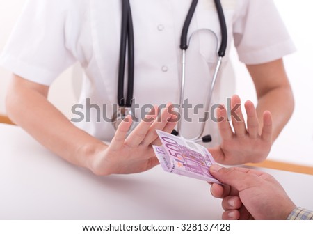 Close up of patient\'s and doctor\'s hands refusing money from bribing