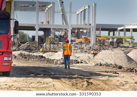 Construction engineer supervising work at building site