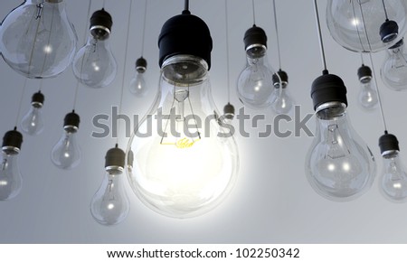 An array of hanging light bulbs with the main one turned on