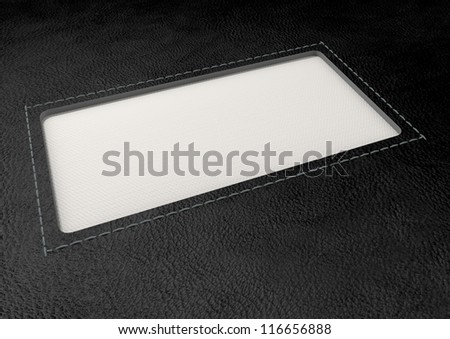 A perspective view of a white woven clothing label sewn into a window cut out of black leather